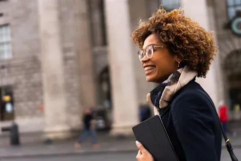 A smiling woman looking confident outdoors.
