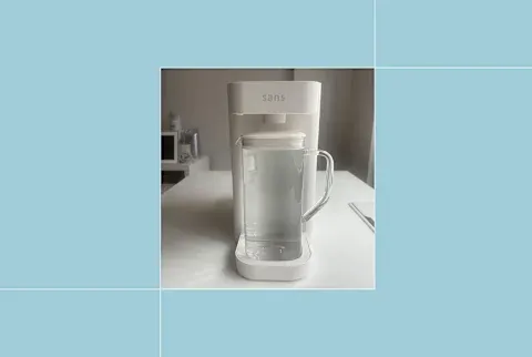 Sans water purifier on writer's counter on blue background