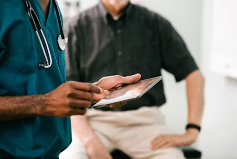 Doctor Enters Information Into Digital Tablet