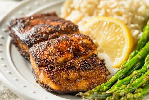 Blackened white fish with asparagus, rice, and a lemon wedge
