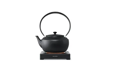 matte black tea kettle resting on a flat warming base from BALMUDA