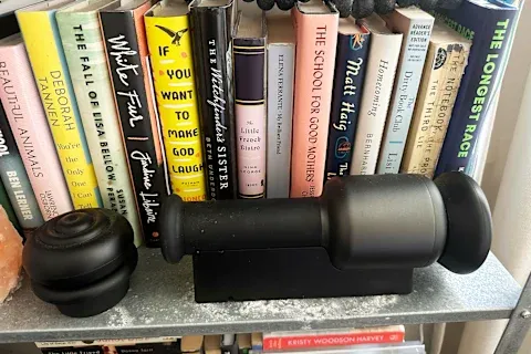 Rally Orbital Massage on bookshelf with attachments stacked