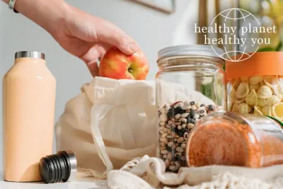 woman reaching into a reusable bag and pulling out produce