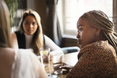 Young woman listening to her friends in a cafe bar