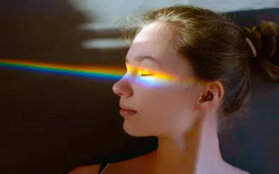 girl with rainbow light spectrum hitting her face