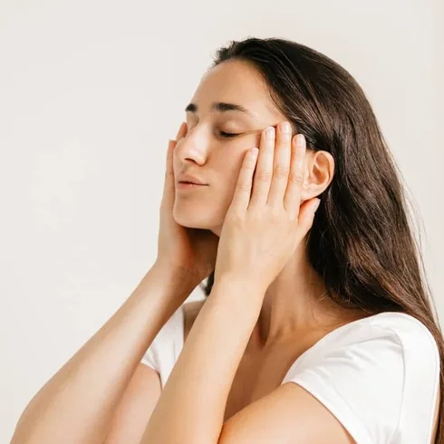 Young Woman Gently Massaging Her Face Young Woman Gently Massaging Her Face