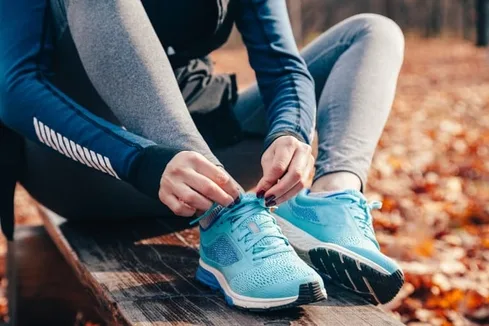 Woman Tying Running Shoes on an Outdoor Run Woman Tying Running Shoes on an Outdoor Run
