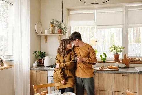 Married couple in love wearing casual outfit spending time together standing in modern kitchen Married couple in love wearing casual outfit spending time together standing in modern kitchen